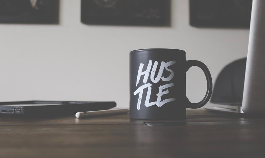 Coffee mug on table reading hustle
